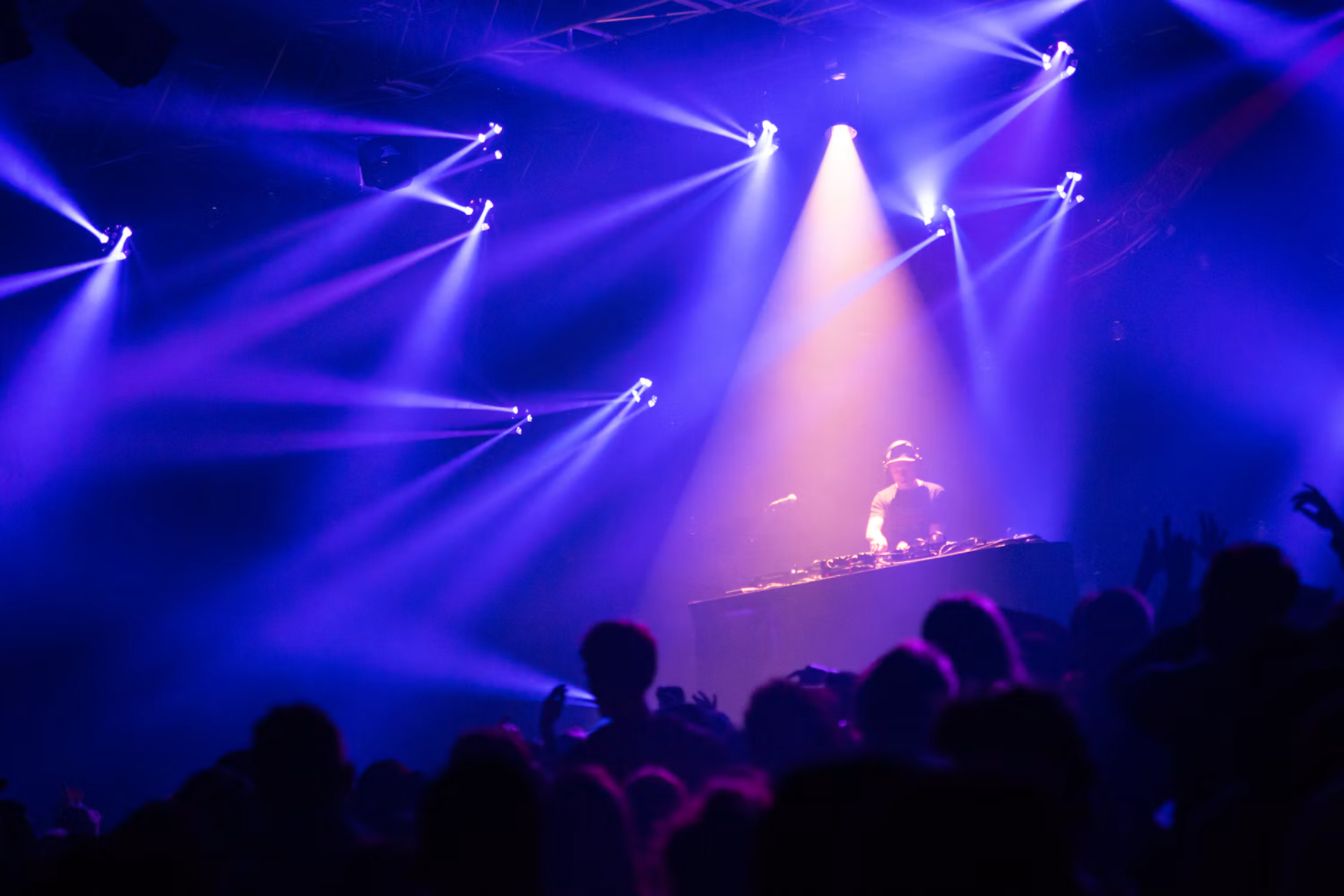 Crowd under purple stage lights at a nightclub
